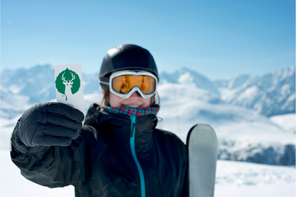 Girl Holding Up Ski Pass on Mountain